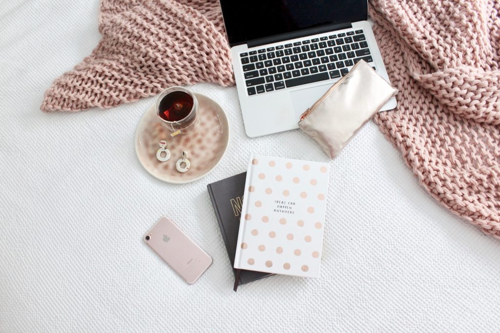 Flatlay photo of laptop, notebook and cup of tea